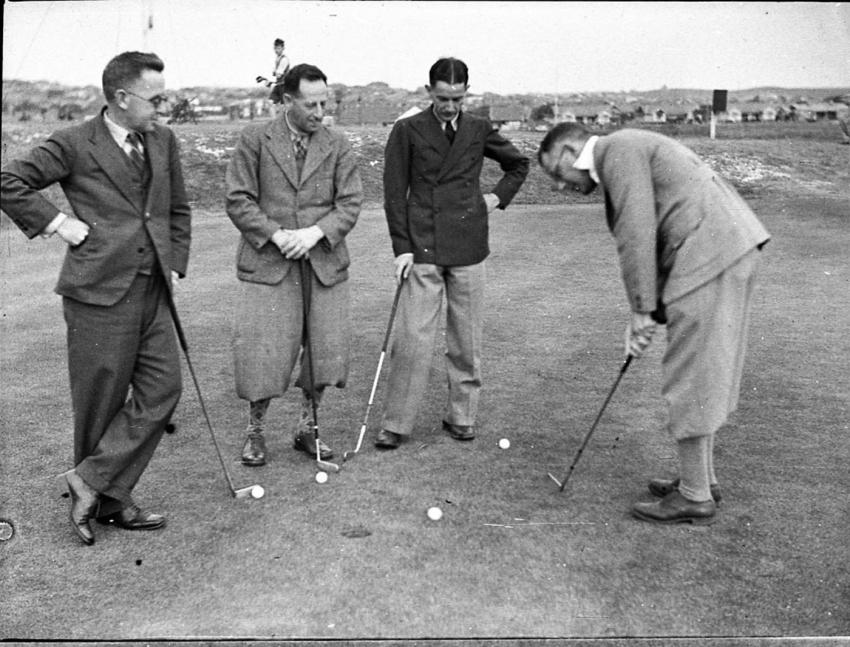 Impeccably dressed gentlemen playing golf.